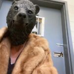 Orphaned cub finds comfort in a teddy bear and costumed caregivers